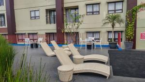 a group of chairs and tables and a building at Fancy and Nice Studio at Atria Residence Gading Serpong Apartment By Travelio in Tangerang
