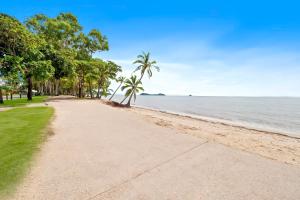 a sandy beach with palm trees and the ocean at Clifton Beach Holiday Villas in Clifton Beach