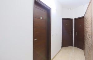 een hal met twee houten deuren in een kamer bij Hotel O New Raj Kamal in Aurangabad