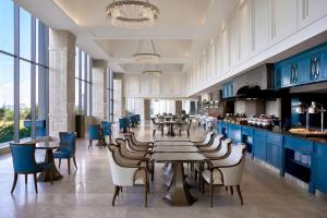 a restaurant with blue cabinets and tables and chairs at Four Points by Sheraton Danang in Danang