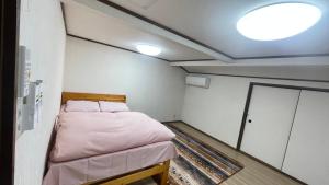 京都市にある薫樹xiang po po innのベッド1台と照明付きの小さな客室です。