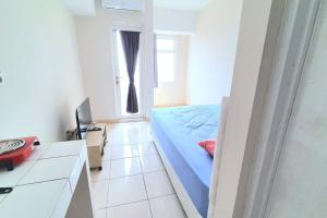 a bedroom with a bed and a desk and a television at Springlake summarecon in Rawabugel
