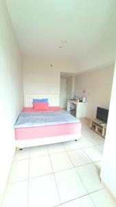 a bedroom with a bed in a white room at Springlake summarecon in Rawabugel +5 photos