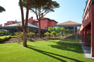 a green yard with a tree and a building at Sheraton Cascais Resort - Hotel & Residences in Cascais