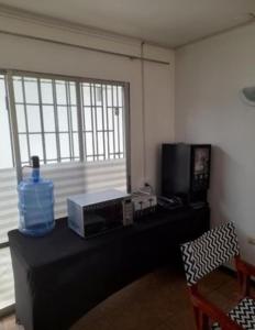 a room with a table with a microwave and a window at Pieza para 1 persona en el centro de La serena con desayuno in La Serena