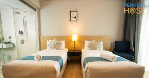 a hotel room with two beds and a lamp at The Straits Melaka by Perfect Host in Malacca +54 photos