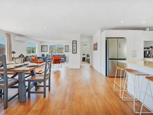 a kitchen and dining room with a table and a kitchen and a living room at Greenhills Charmer - Coromandel Town Holiday Home in Coromandel Town