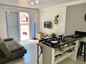 a kitchen with a counter and a chair in a room at Loft Aconchegante Apartamento Floripa 12 - Wi-fi 600Mb in Florianópolis