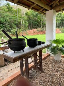 three pots and pans sitting on a table at Sitio Reis Membeca in Paraíba do Sul