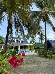 a house on the beach with palm trees and flowers at South Pearl Villas 