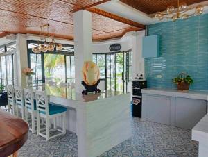 a kitchen with a bar with chairs and a table at South Pearl Villas 