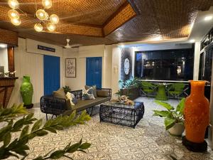 a living room with a couch and chairs and vases at South Pearl Villas 