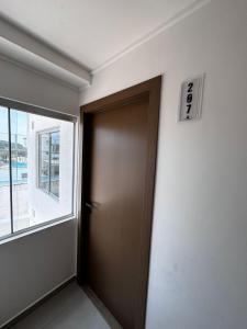 a brown door in a room with a window at Menacho Apartamento - Mangales Blue Norte in Santa Cruz de la Sierra +20 photos