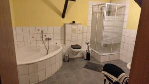 a bathroom with a tub and a toilet and a shower at Ferienwohnung Höfen bei Uchte in Uchte