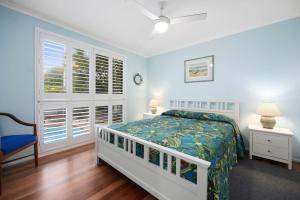 a white bedroom with a bed and a window at Allamanda Sands in Peregian Beach +9 photos