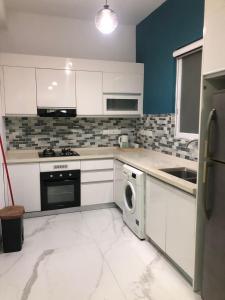 a kitchen with white cabinets and a washer and dryer at Mount Oasis Residency at Blue Ocean in Watumulla