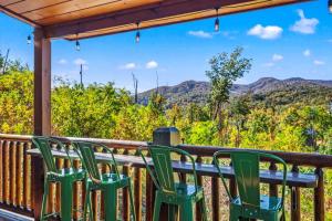 a group of green chairs on a porch with a view of mountains at Indoor Pool, Volleyball Beach, Mountain View, Luxury in Gatlinburg