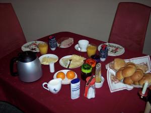 una mesa roja con comida para el desayuno y bebidas. en Gästezimmer Charlotte, en Dresden