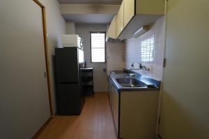 a small kitchen with a sink and a refrigerator at 浜ノ町瀬戸凪 in Takamatsu
