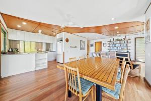 a kitchen and dining room with a wooden table and chairs at Claytons 7 by Discover Stradbroke in Point Lookout