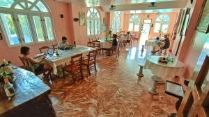 Un restaurante con gente sentada en mesas con agua en el suelo. en Scenic View Tourist Inn, en San Juan