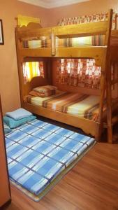 two bunk beds in a room with a wooden floor at Baguio Transient Whole House in Baguio