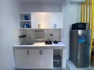 a small kitchen with a sink and a refrigerator at Kidapawan Staycation 2 in Manongol
