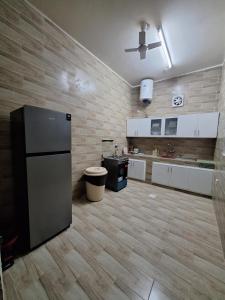 a large kitchen with a refrigerator and a counter at Al Falak Chalet in Al Raka