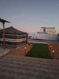 a large tent with lights on the grass at Al Falak Chalet in Al Raka