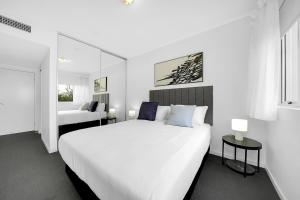 a white bedroom with a large white bed and a window at Trilogy Residences Brisbane in Brisbane +36 photos