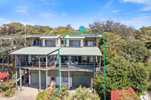 an apartment building with a green address sign on it at Claytons 7 by Discover Stradbroke in Point Lookout