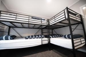 two bunk beds in a room with white and blue pillows at Kilsby Sinkhole & Accommodation in Mount Schank