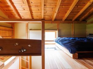 a bed in a room with a wooden ceiling at 隠れ家stay蔵ひなわら in Ohnan-cho +28 photos