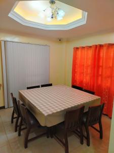 a dining room table with chairs and a ceiling at Baguio Transient Whole House in Baguio +3 photos