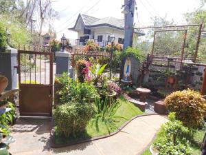 a garden in front of a house with a gate at Baguio Transient Whole House in Baguio