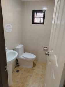 a bathroom with a toilet and a sink at Baguio Transient Whole House in Baguio