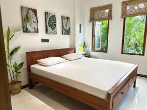 a bedroom with a large bed with white sheets at The Green Heaven Villa in Ambalangoda
