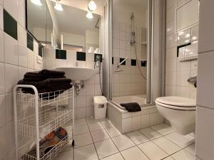 a white bathroom with a sink and a toilet at Ferienwohnung De Diek 105 in Dorum