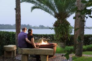 a man and woman sitting next to a fire pit at Black Dolphin Inn in New Smyrna Beach