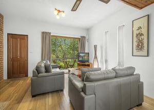 a living room with two couches and a television at Banksia in Sawtell