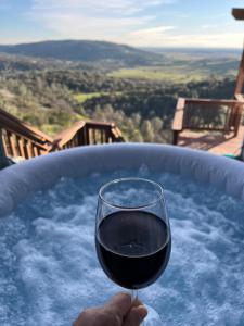 a person holding a glass of wine in a hot tub at Breathtaking view of the Hills with HotTub, Pool and Pool Table in Marble Mountain