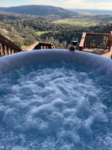 a bath tub filled with water with a glass of wine at Breathtaking view of the Hills with HotTub, Pool and Pool Table in Marble Mountain
