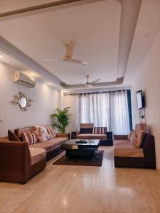 a living room with two couches and a table at Hostmystay- 3Bhk Terrace! Gk1 M block in New Delhi