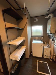 a room with two bunk beds and a window at furano Hokuseisanso I in Furano