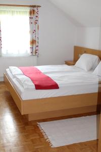 uma cama com um cobertor vermelho num quarto em Ferienwohnung Seiringer em Attersee am Attersee