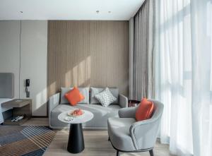 a living room with a couch and a table at Holiday Inn Express Yinchuan Lanxi Valley Plaza by IHG in Yinchuan