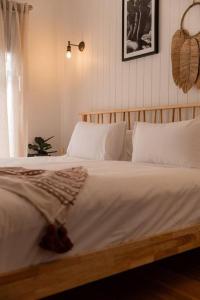 ein Bett mit weißen Laken und Kissen in einem Schlafzimmer in der Unterkunft Bay Hideaway Stieglitz in Saint Helens Island