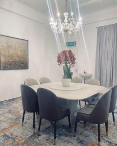 a dining room with a table and chairs and a chandelier at Yawang homestay in Kota Bharu