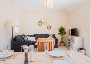 a living room with a table and a couch at The Barn in Longhope - Luxury Barn Conversion in Longhope