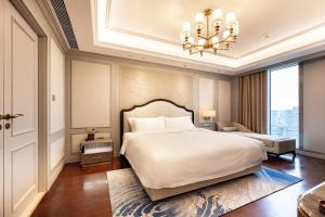 Postel nebo postele na pokoji v ubytování Jian Guo Hotel Yantai Phoenix Building
